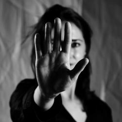 Photo d'une femme se cachant derrière sa main
