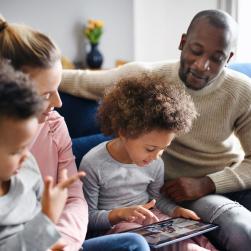 Photo d'une famille dont la petite fille a une tablette